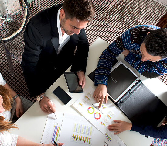 top down view of business team reviewing charts and graphs