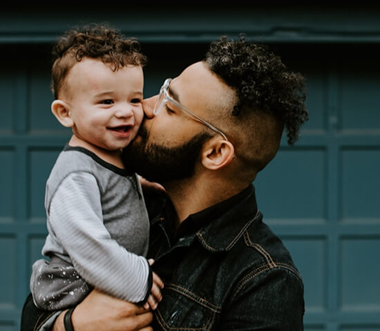 man kissing son on cheek