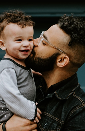 dad kissing son on cheek