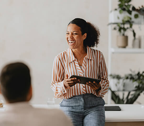 woman with tablet speaking to a room
