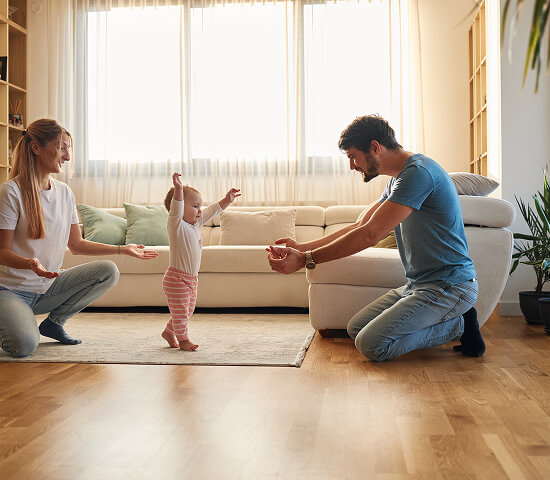 parents with young baby learning to walk