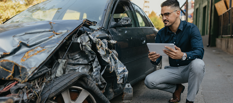 Insurance Agent Inspecting Damaged Vehicle